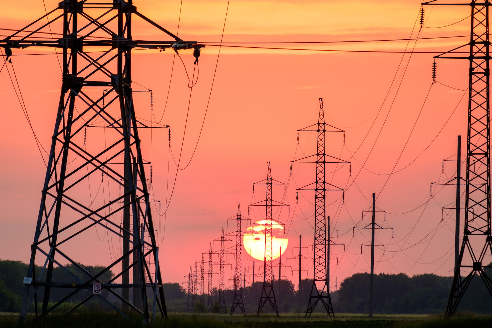 silhouette of electric post during sunset