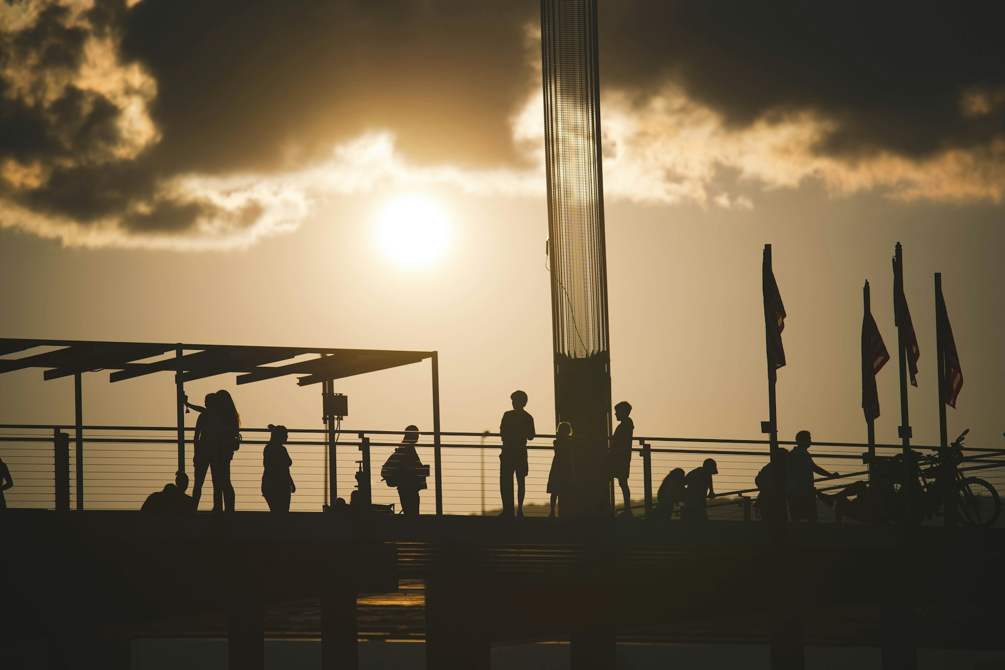 Silhouettes of people on top of a building in Riverfront, Chattanooga, Tennessee at cloudy sunset